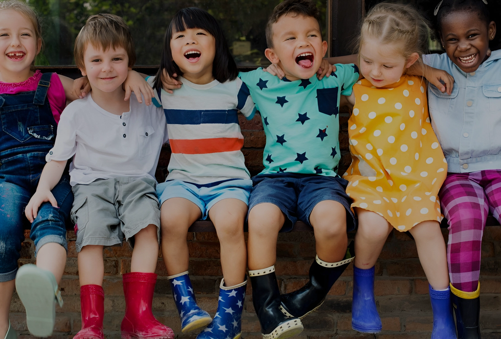 A group of children sitting on top of a bench.