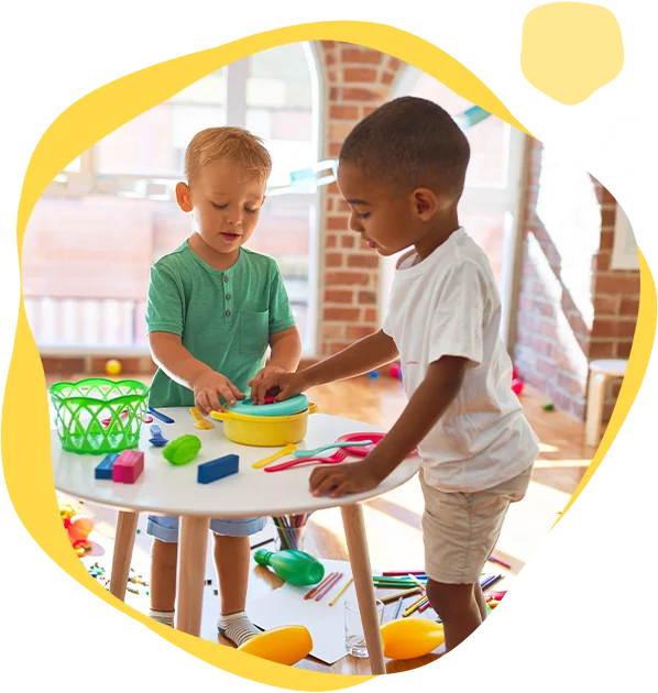 Two young children playing with toys on a table.