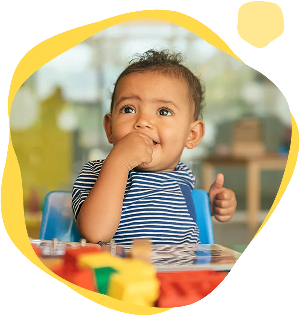 A baby sitting in a high chair eating some food.